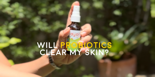 Hand holding Ayo Skincare Probiotic Spray bottle outdoors, highlighting probiotic benefits for clearer skin.